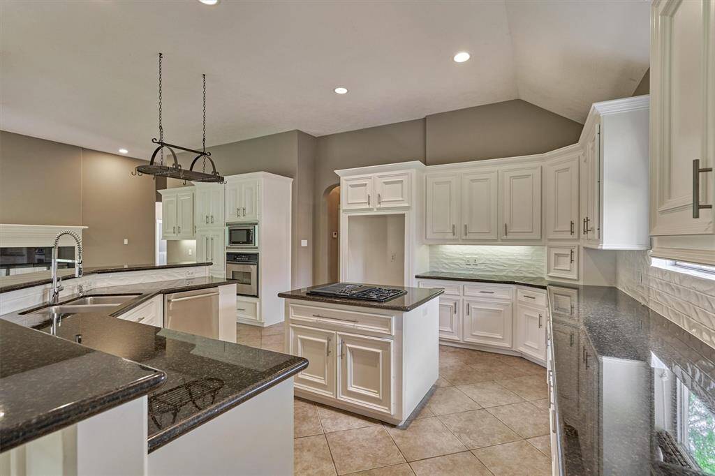 The updated subway tile backsplash compliments the white cabinetry and sparkling granite countertops.