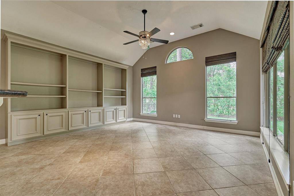 The main living area is just off of the kitchen and has large picture windows, custom cabinetry and tile flooring.