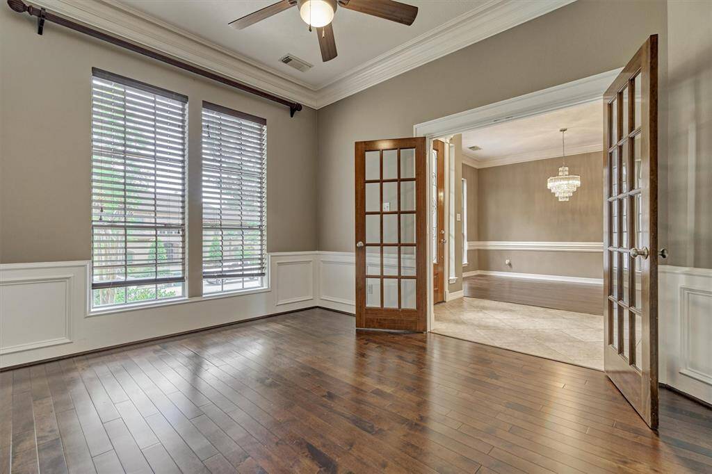 Rich wood flooring and crown molding in this comfortable home office.