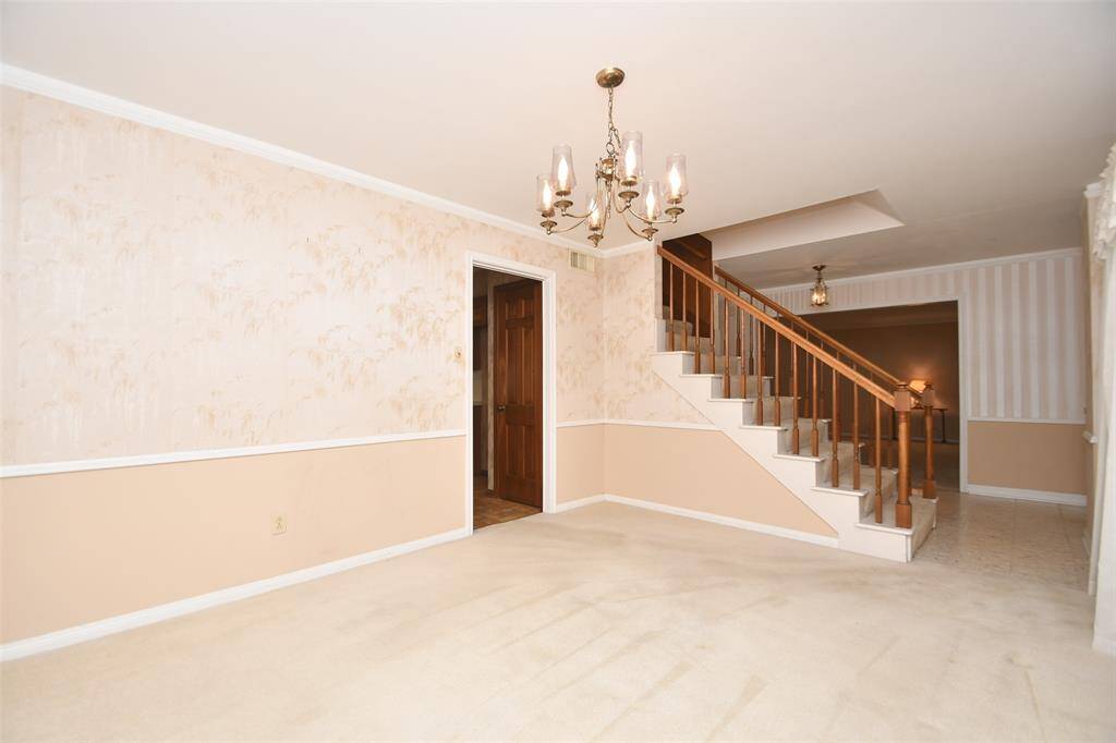 A view from the dining area. The kitchen is on the left and the living room is straight ahead. The family room is at the back of the house, directly through the entry.