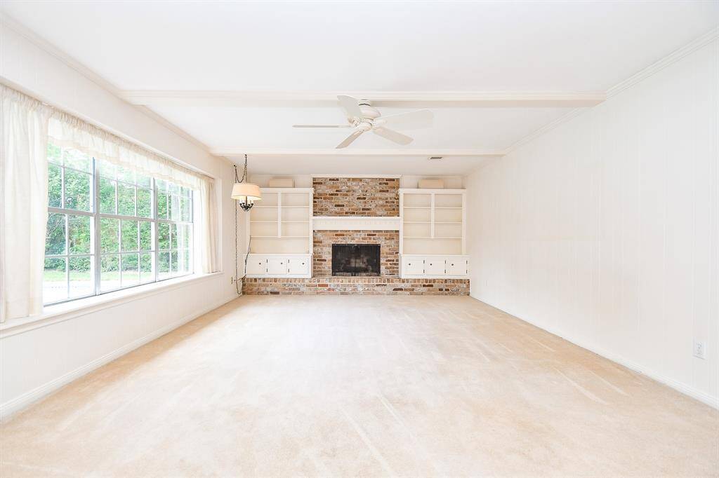 This spacious home offers two large living areas, a formal dining room, and a kitchen that opens to a sunny breakfast nook. This family room has a wall of windows and overlooks the pool.