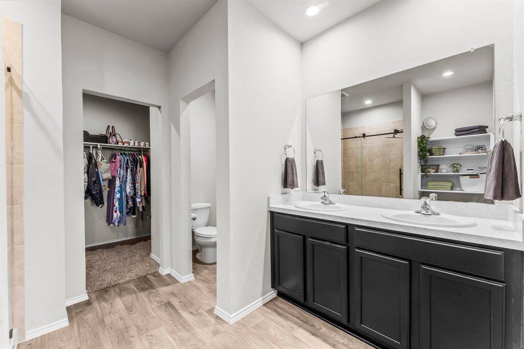 Primary bathroom with double vanity sinks and so much storage.