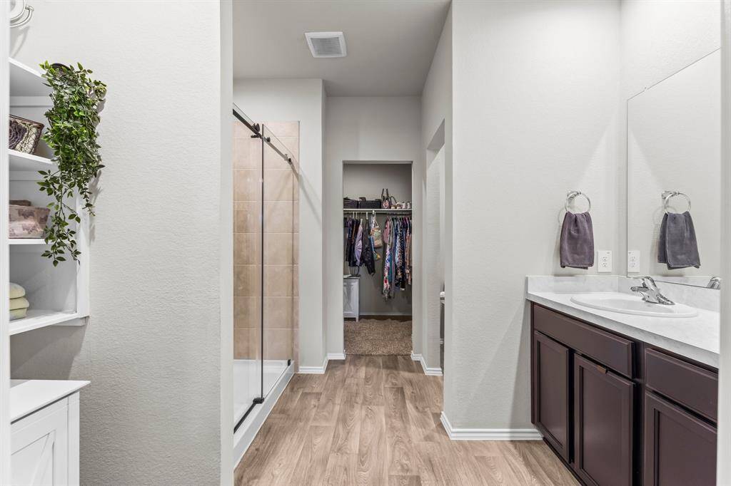 Primary bathroom with attractive and functional built in shelving as you walk in the spa like space.