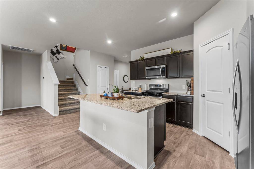 Large granite island and stainless steel appliances.