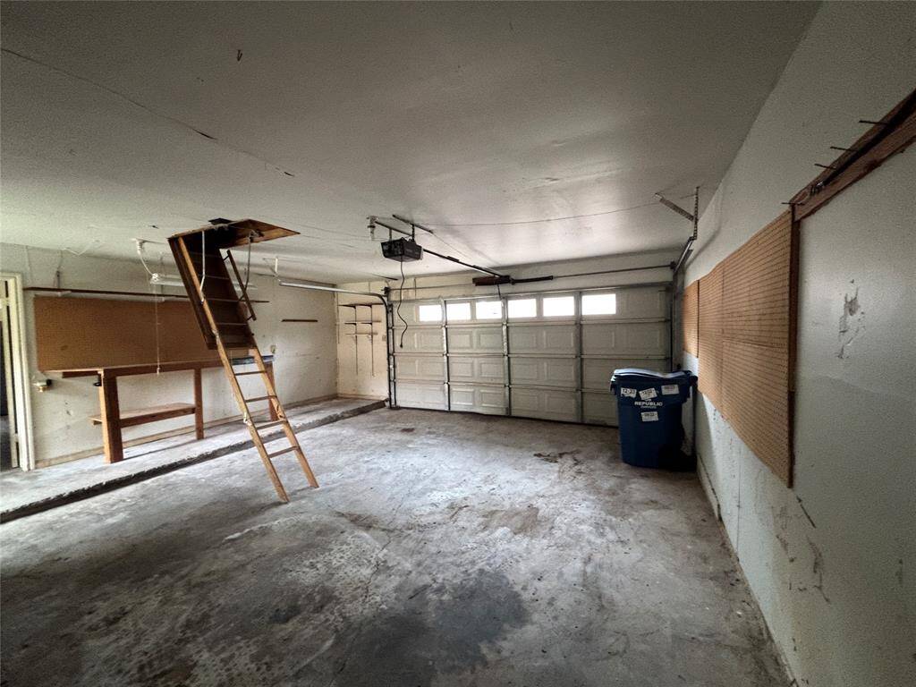 The garage is spacious and has easy access to the attic for storage.