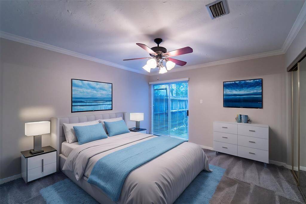 This bedroom features a modern design with neutral walls. It includes a ceiling fan, ample natural light through windows with blinds, and a personal porch whose location is the front side of the home.