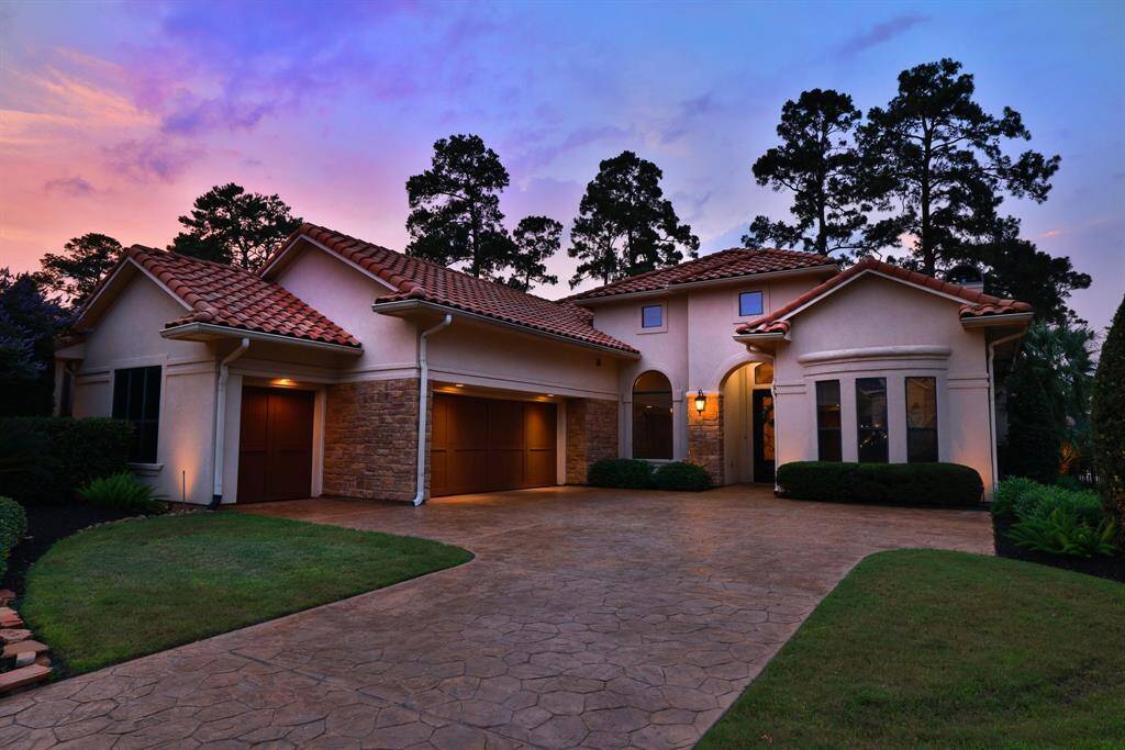Stunning two-story home with a Mediterranean-style design featuring a red-tiled roof and arched windows in the heart of Northgate Forest.