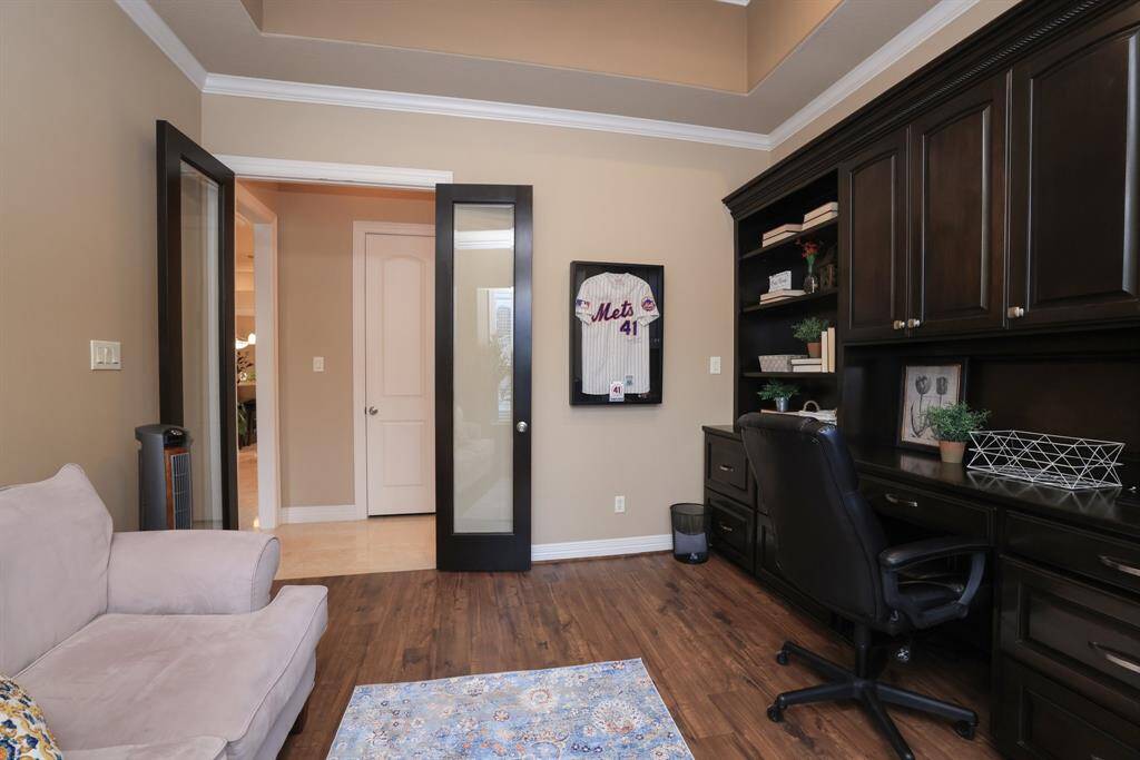 A glass door opens to a hallway with a convenient half bath nearby. This spacious room is perfect for a home office and a cozy conversation area.
