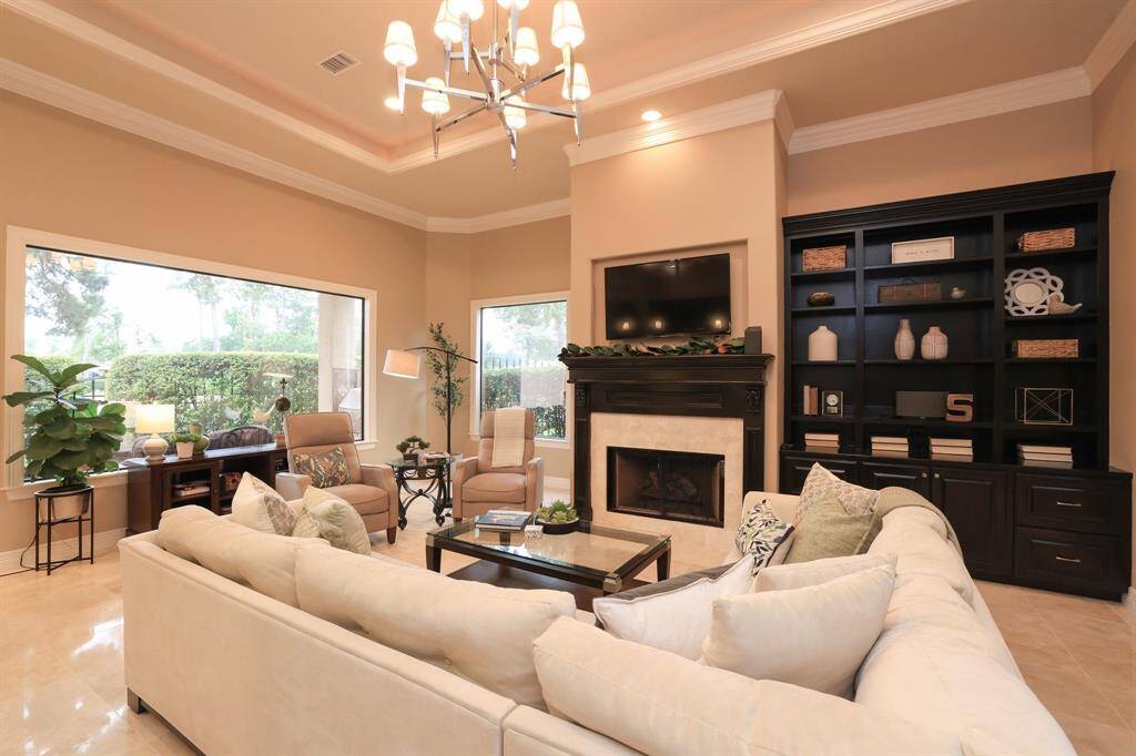 Flooded with natural light from expansive windows, this inviting den is perfect for relaxing with a book or enjoying a movie.