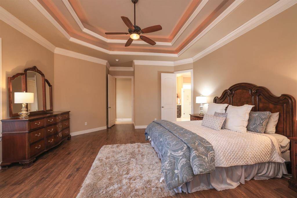 Features also include a lighted ceiling fan & and warm cove lighting. creating a comfortable and inviting atmosphere.  The entrance to the Master Bath is to the right.