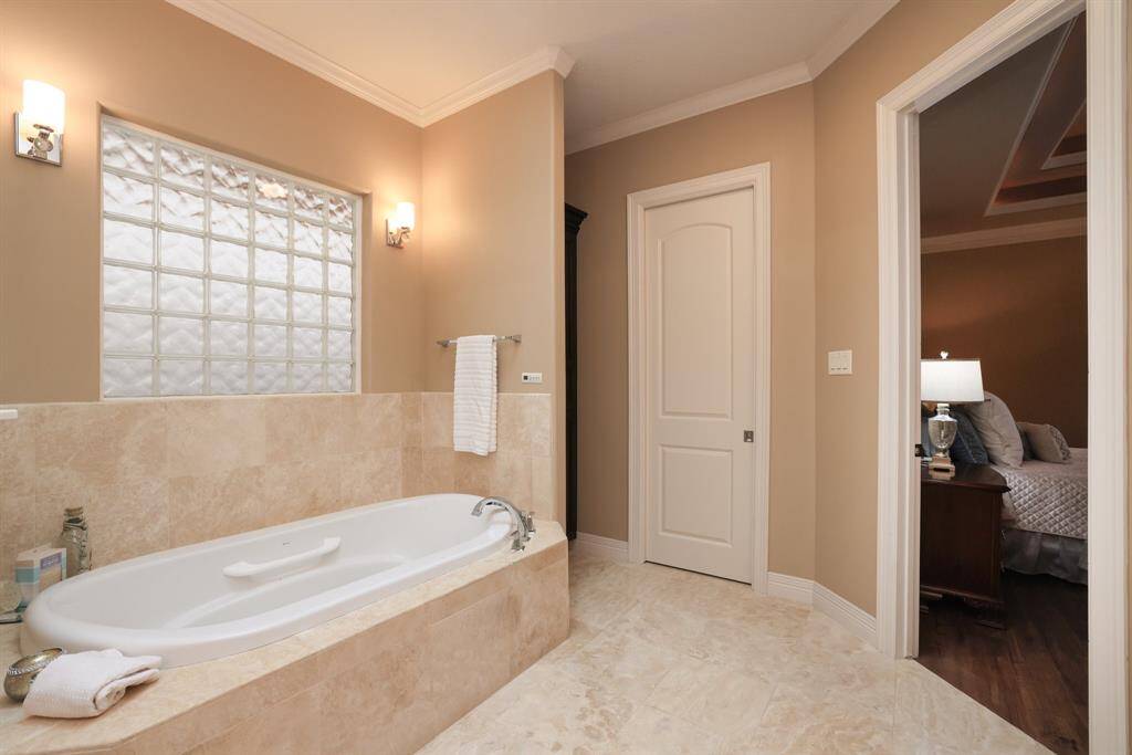 This spacious walk-in master closet, accessible through a sleek pocket door, features custom built-ins to meet all your storage needs.