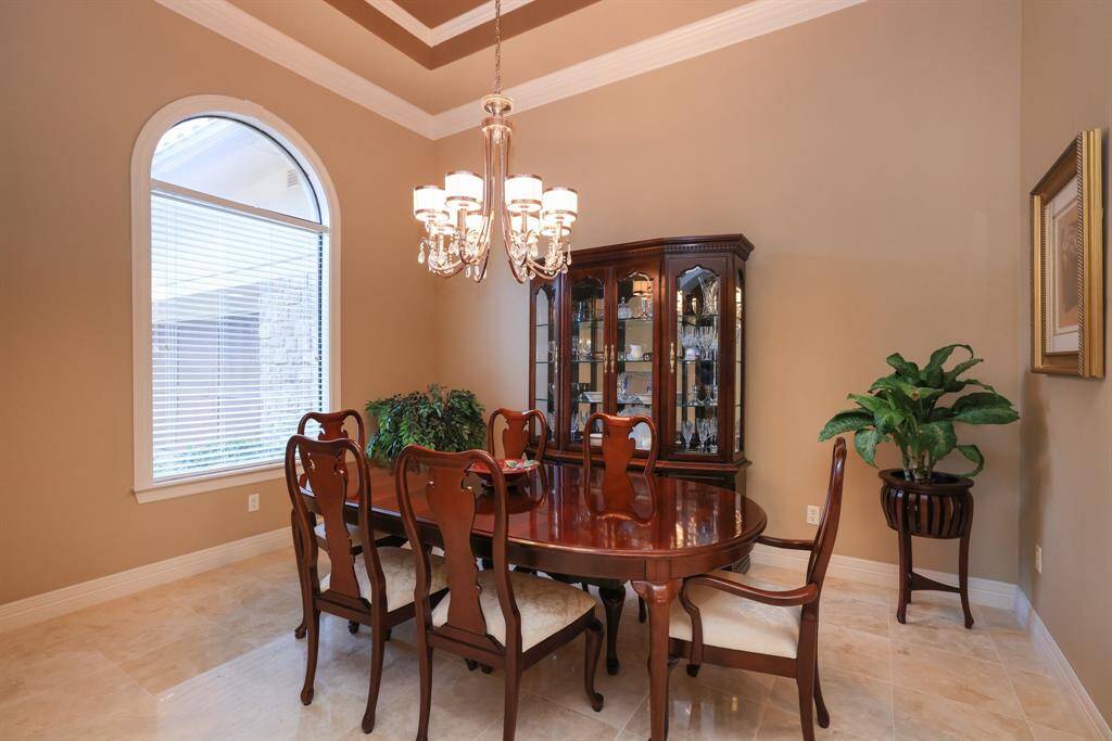 This stylish dining room is brightened by a large arched window and complemented by warm, neutral walls and tile flooring. The stunning chandelier compliments the space beautifully.