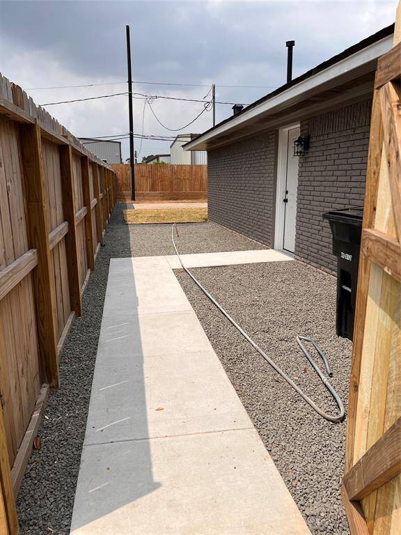 Entering through front gate. Door leads to garage (metal pipe waiting to be put out to heavy trash)