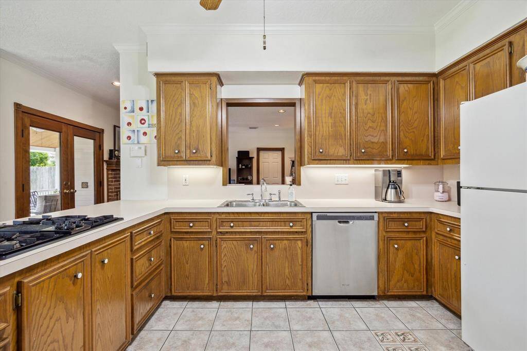 The Kitchen offers abundant storage and a layout that allows for distinct spaces, yet includes peek-through opening to stunning Living Room/Den, facilitating seamless flow and entertaining.