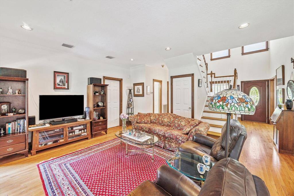 Another view of the Living Room reveals its spaciousness and natural light. Doors provide access to the laundry room, a full bath downstairs, and ample storage.