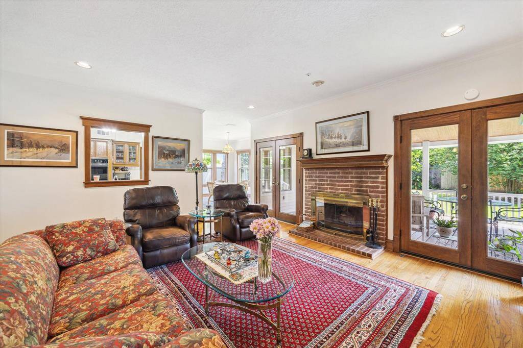 Enjoy an additional view of the Living Room, where a peek-through design enhances the semi-open floor plan, seamlessly connecting spaces while maintaining a sense of intimacy. The room is filled with abundant natural light, highlighting the handsome hearth that serves as a focal point, offering warmth and elegance.