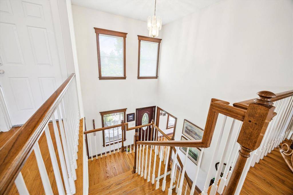 The striking center staircase is breathtaking in person, beautifully complemented by dramatic windows and oak wood accents.