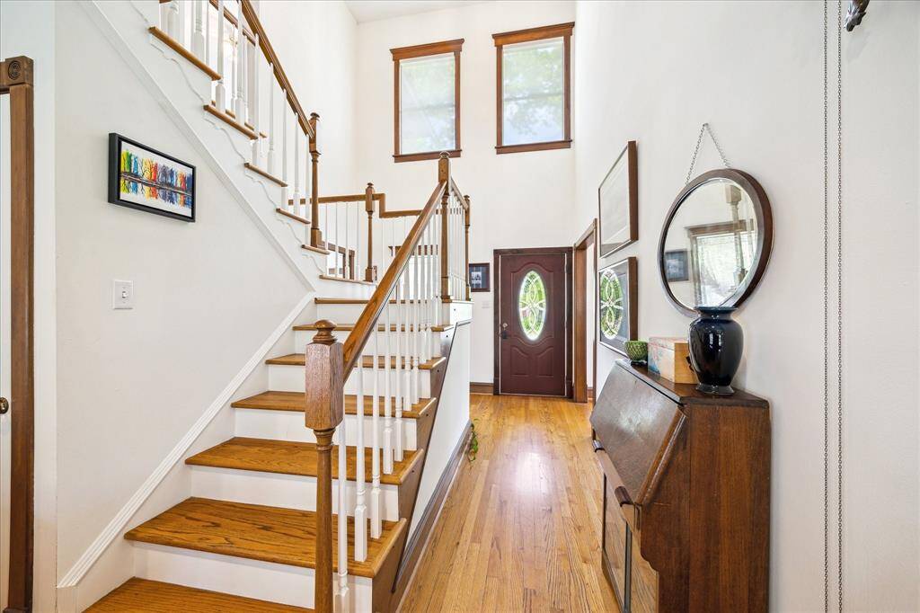 The home boasts a central hall and stairwell, elegant woodwork, plentiful natural light, and high ceilings.