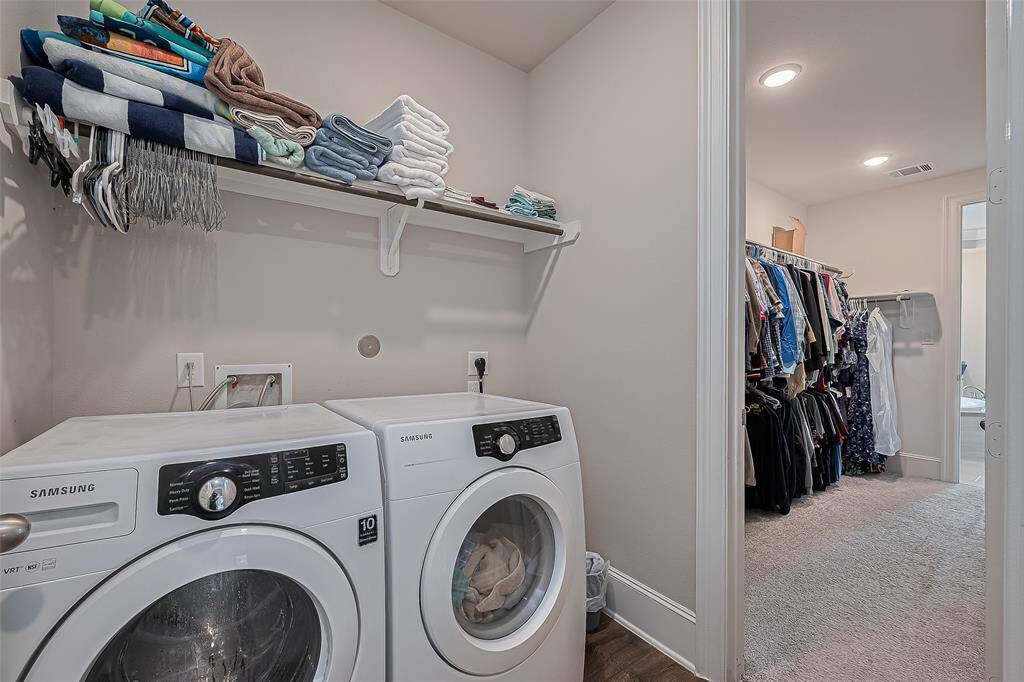 Laundry room connected to primary walk-in closet