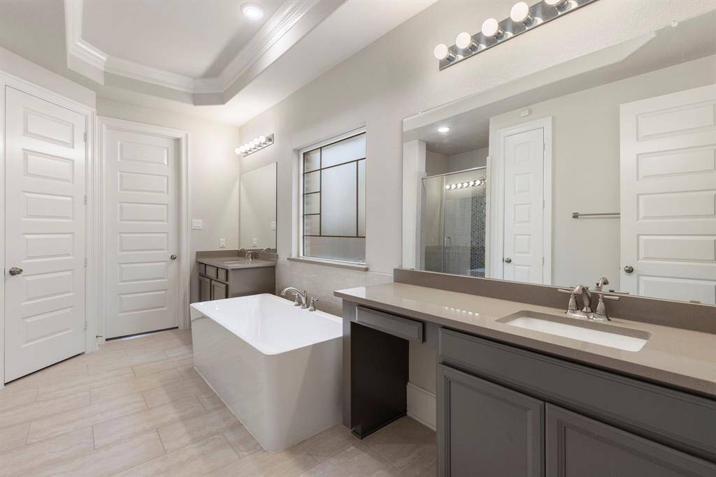 Walking into the Primary bathroom, you will find separate sinks, a vanity space, a freestanding tub and a separate oversized shower.