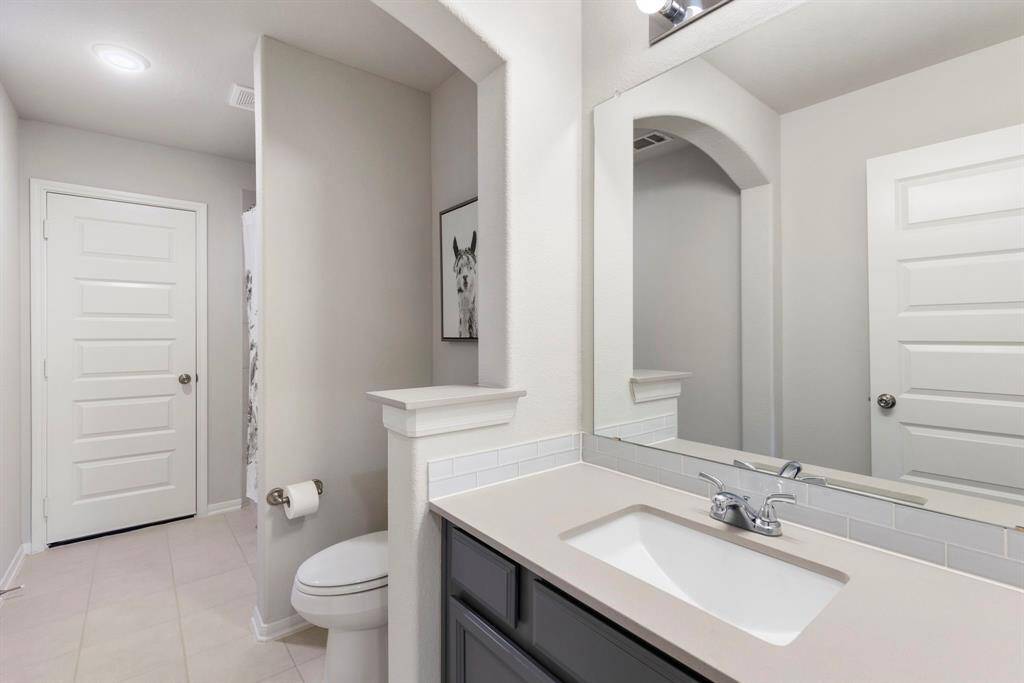 The ensuite bathroom has a large walk-in closet, with a tub/shower.