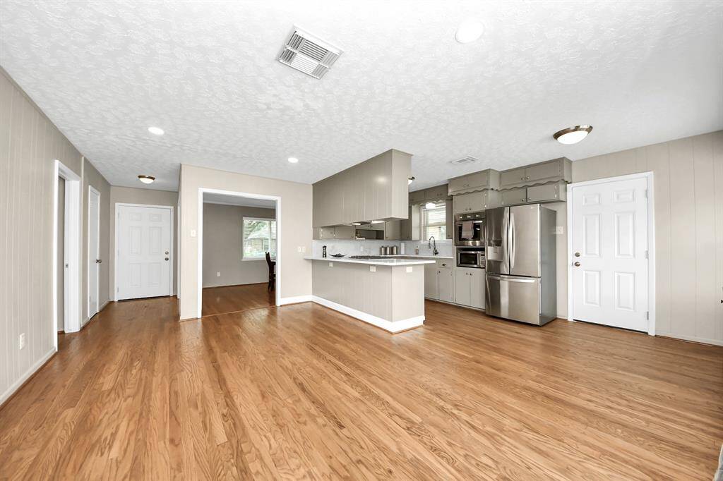 Inviting family room with seamless flow from the front entry, featuring warm hardwood floors and abundant natural light.