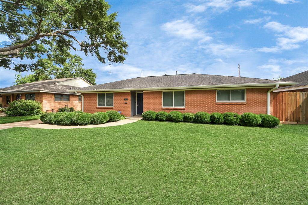 Welcome home to a charming brick exterior with a well-manicured lawn and inviting walkway leading to the front door.