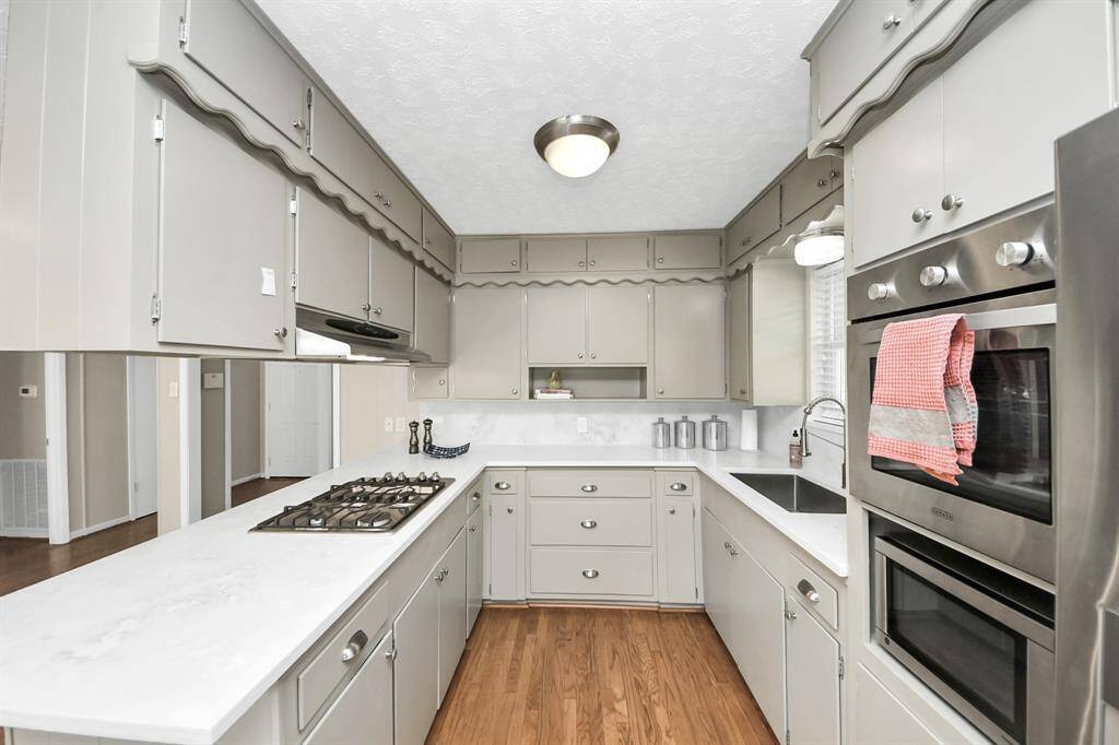 Experience elegance in the kitchen with stunning cherry hardwood floors.