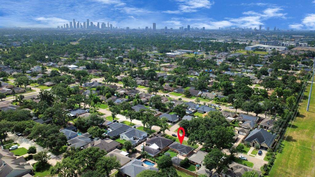 Stunning aerial view showcasing a charming neighborhood with lush greenery, conveniently located near the city skyline. Perfect blend of tranquility and urban accessibility.