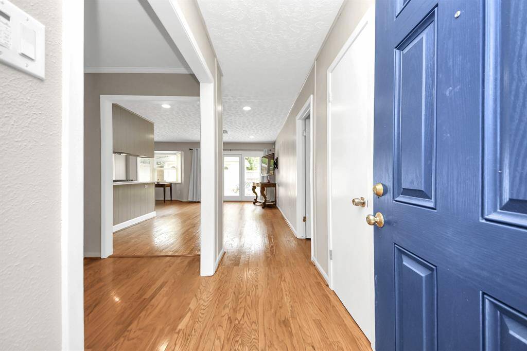 Welcoming entryway with elegant hardwood floors and abundant natural light, leading into spacious living areas.