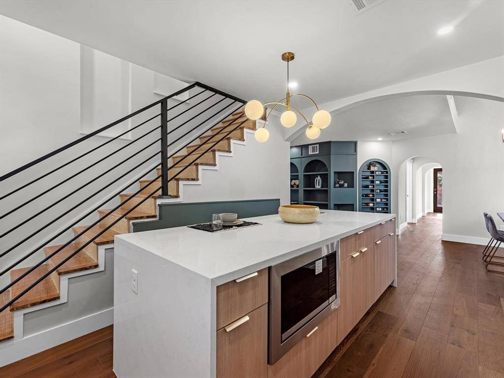 Newly added stairs with custom iron metal railing and Red Oak treads, leading to the converted upstairs attic space.