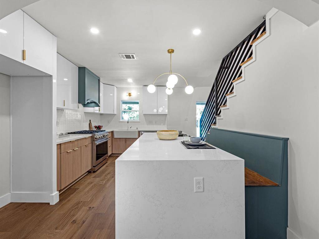 Spacious kitchen island featuring a custom-built bench and decorative lighting for added style and functionality.