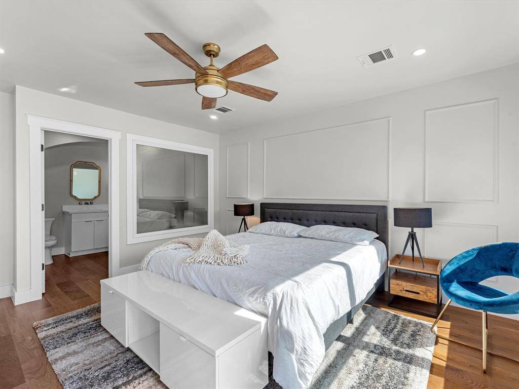 A frosted designer window seamlessly transitions between the primary bedroom and bathroom, adding a modern touch while maintaining privacy.