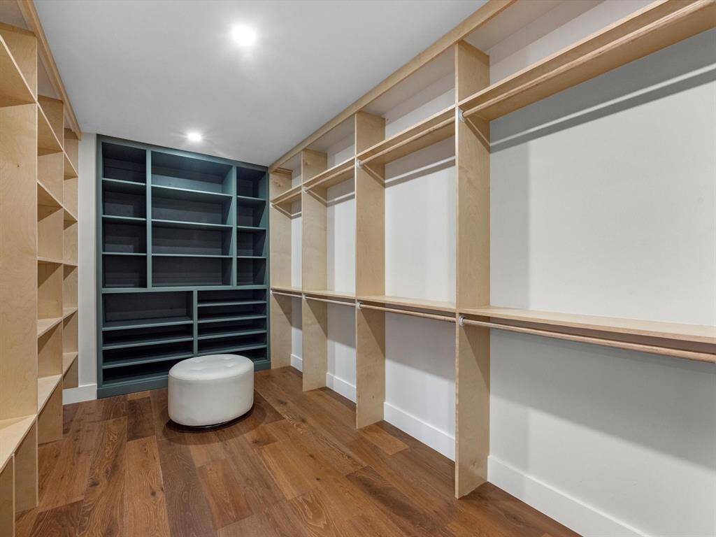 The primary closet is exceptionally spacious, featuring custom-built shelving, abundant storage options, and ample room for organization and functionality.