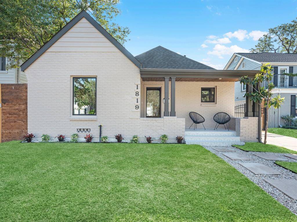 Charming freshly painted brick exterior with modern accents, professional landscaping, and a cozy front porch with decorative tile steps, offering a perfect blend of curb appeal and style.