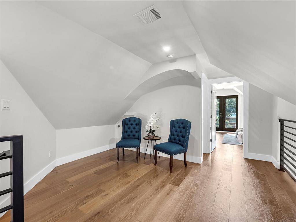 The upstairs attic conversion features a bright and airy loft flex space with elegant wood flooring, perfect for a seating area, home office, or additional living space.