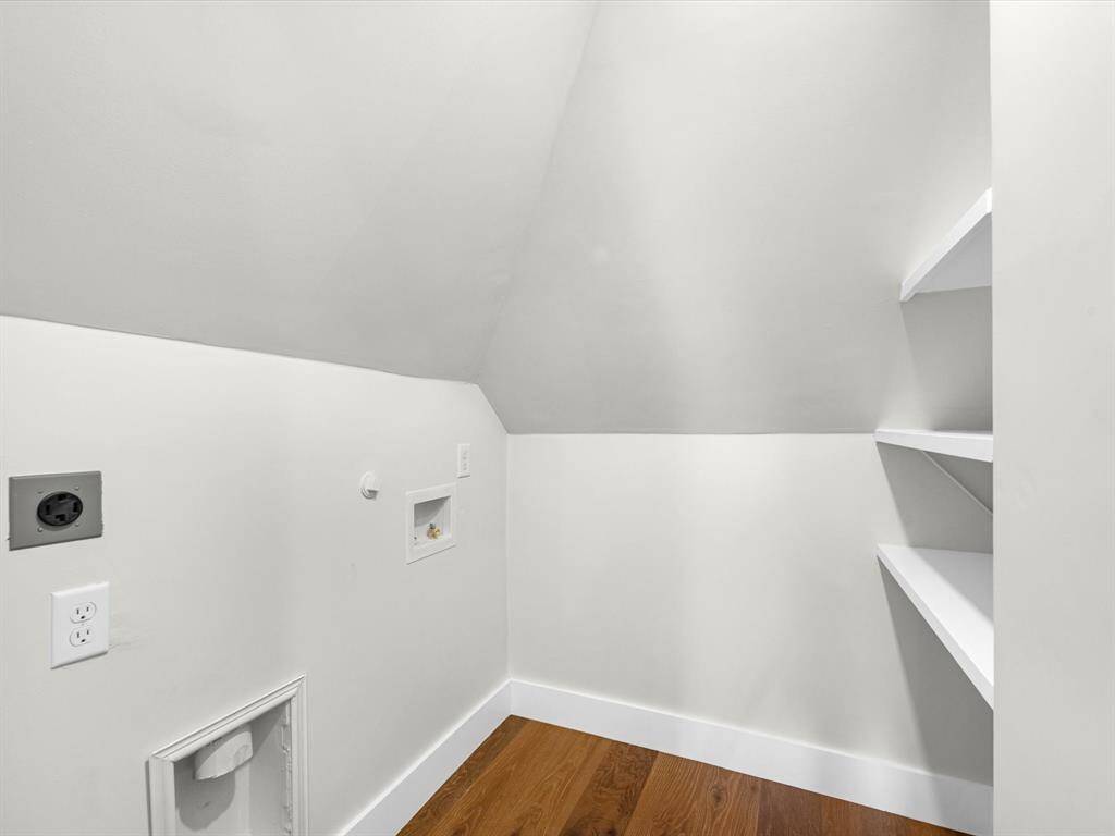 The laundry room features built-in shelving for convenient storage, maximizing functionality in this space.