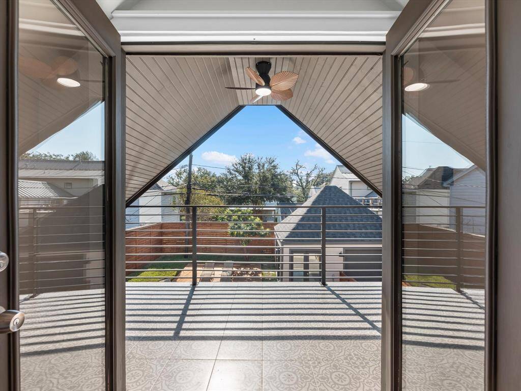 Double doors open to a spacious second-floor balcony, offering sweeping views of the backyard and a perfect outdoor retreat.