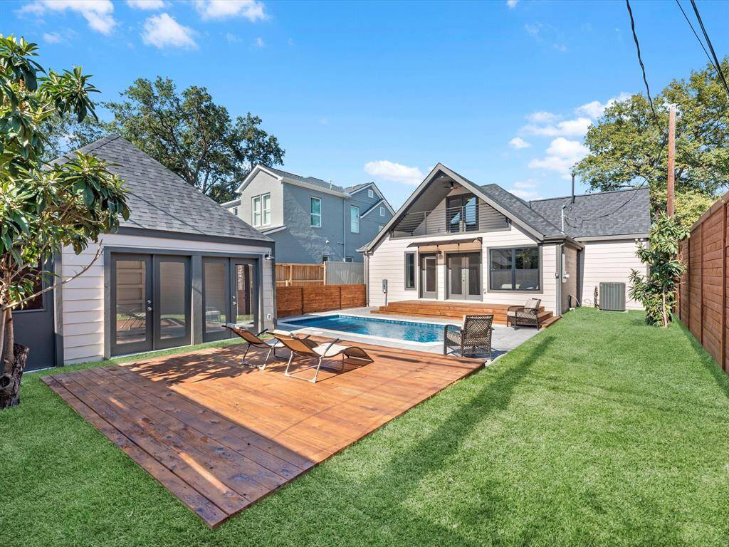 The backyard offers plenty of green space beyond the decking and pavers surrounding the pool, providing ample room for relaxation or outdoor activities.
