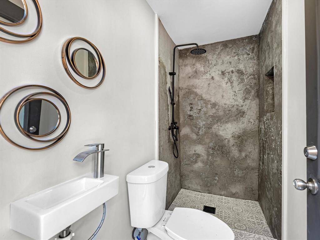 The pool house bathroom is designed for convenience, offering easy access for backyard entertaining with a modern shower, stylish fixtures, and durable finishes.
