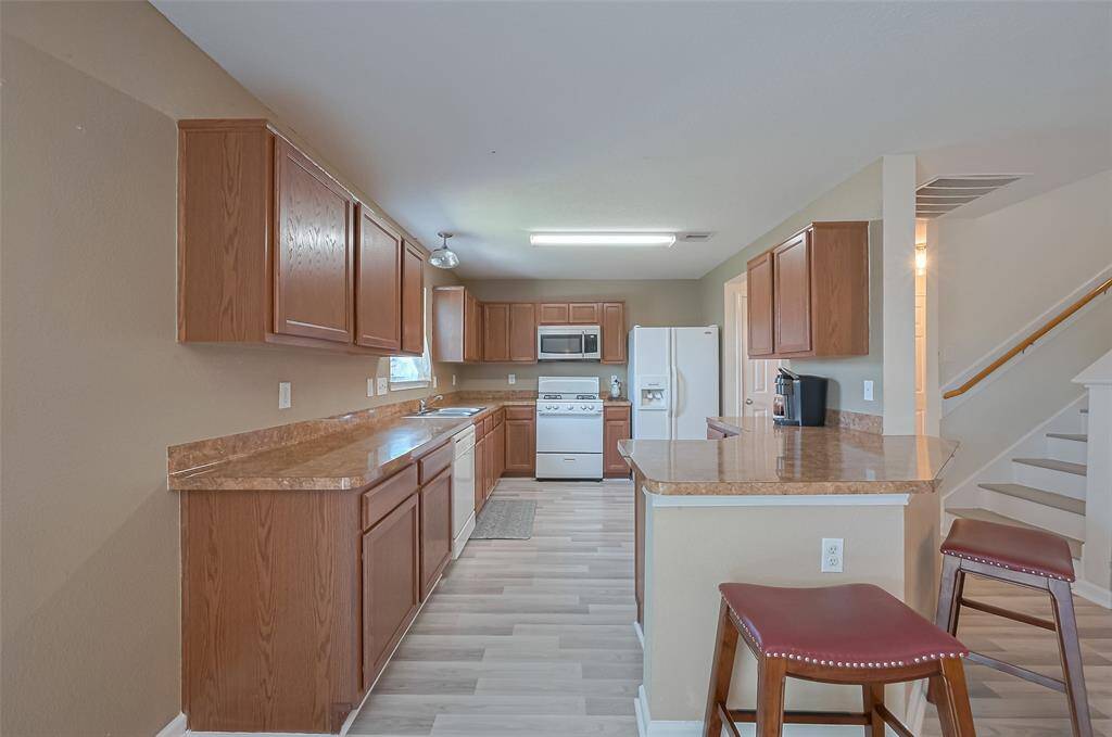 Kitchen boasts generous upper and lower cabinetry, as well as a curving counter with built-in storage and seating.