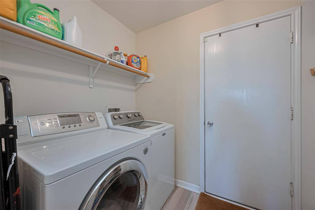 A dedicated laundry space features a built-in overhead rack for convenient storage above your washer and dryer