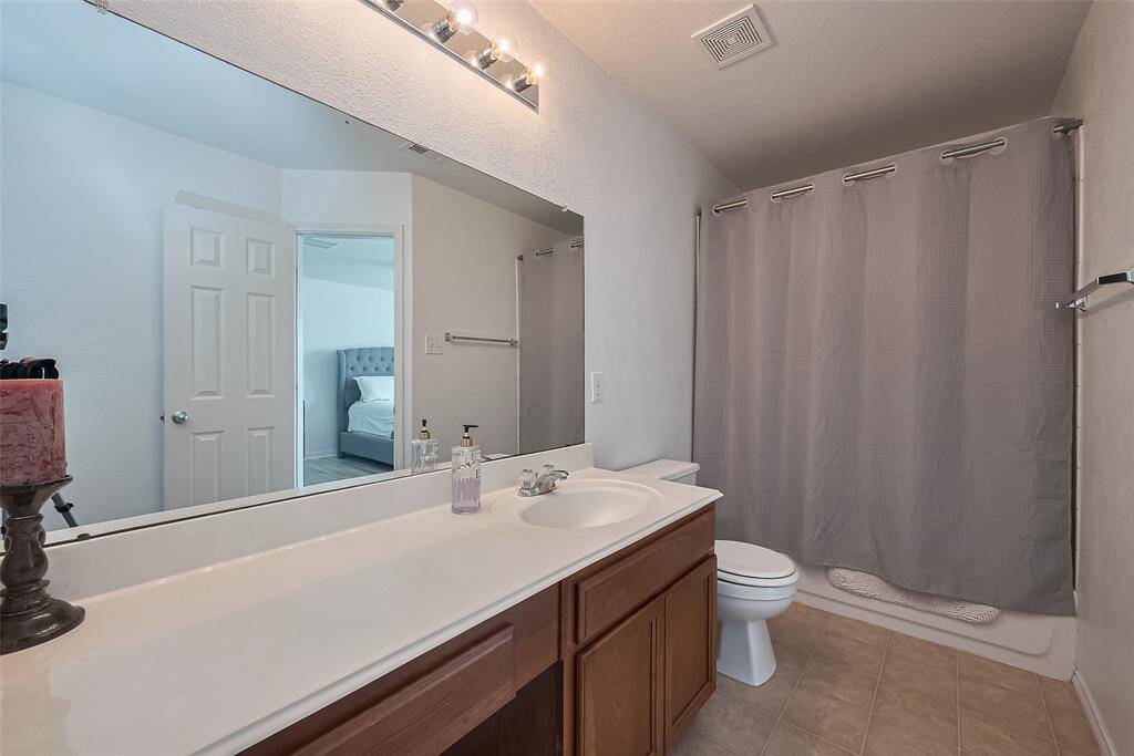 Suite bath features a wide vanity with ample storage and a large mirror