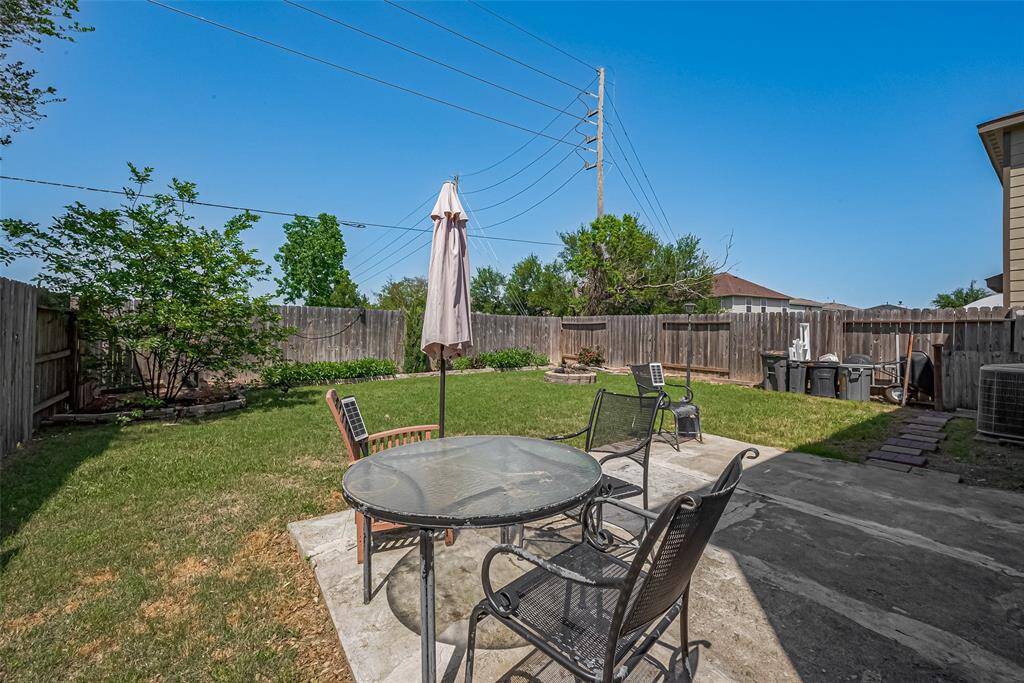 Step outside to a generous open-air patio—an ideal setting for outdoor dining or simply enjoying the view across the green backyard.