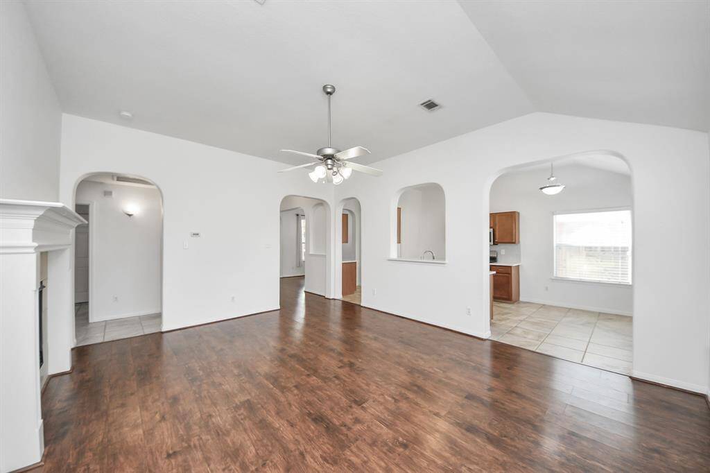 Open-concept living with architectural arches and easy access to kitchen and hallway.