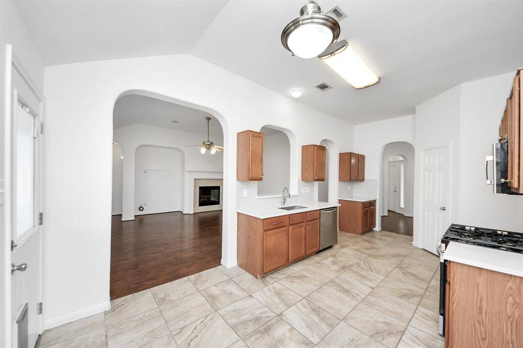 Modern kitchen with NEW QUARTZ COUNTERS and clear sightlines into the living room.