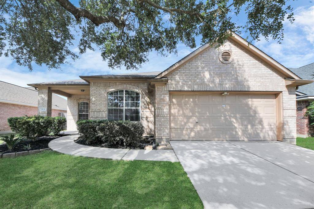 Inviting brick exterior with covered front porch, lush landscaping, and a BRAND NEW ROOF (2025).