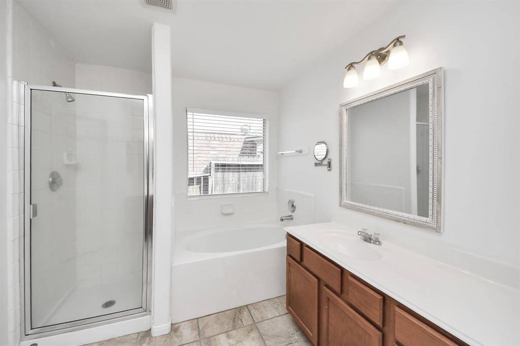 Light-filled primary bath with timeless finishes and ample counter space.