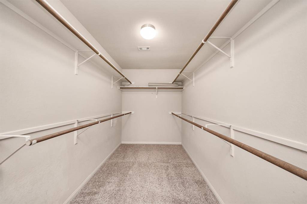 Massive walk-in closet with abundant hanging space and built-in shelving.