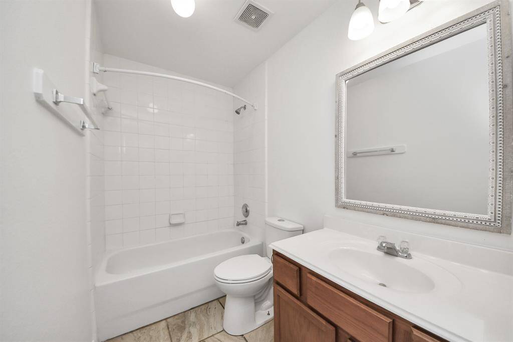 Bright and clean full bathroom with tile flooring and a classic tub/shower combo.